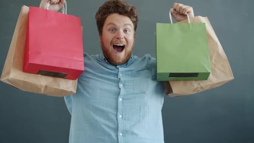 Excited Man Holding Colorful Shopping Bags