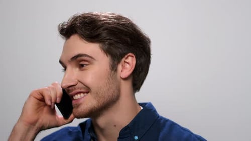 Positive Man Talking on Smartphone on Light Background. Guy Calling on Cellphone