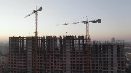 In the Background Working Crane and City. Aerial Shot of the Building in the Process of Construction