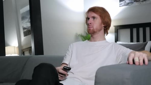 Man Relaxing on Couch, Holding Remote Control