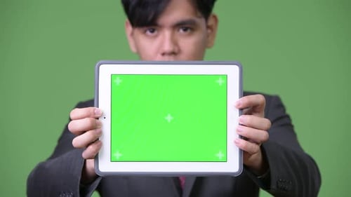Young Adult Holding Tablet with Green Screen Display