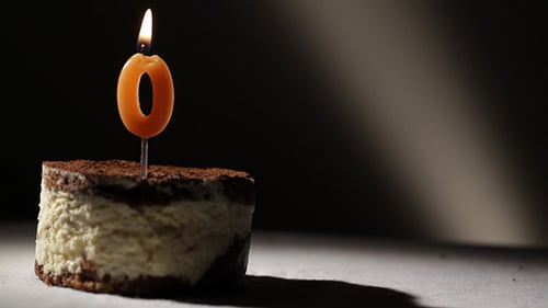 Cheesecake with Number Zero Birthday Candle Lit