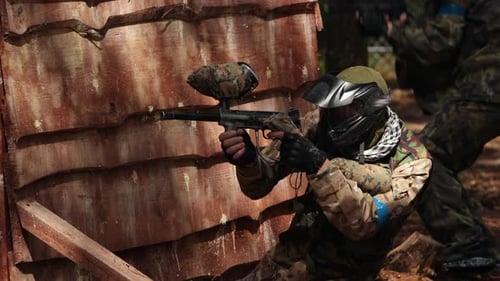 Paintball Sportspieler trägt Schutzmaske beim Schießen