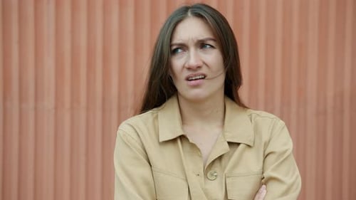 Portrait au ralenti d'une jeune femme ennuyée bâillant en regardant la caméra debout à l'extérieur