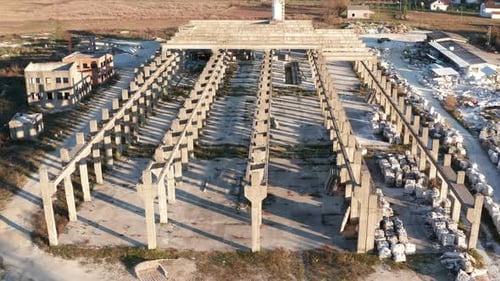 Abandoned construction of an industrial hall for a factory - concrete studs, joists, columns, posts.