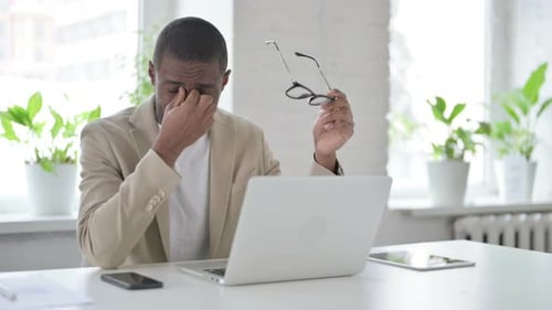 Tired Man Working on Laptop in Office