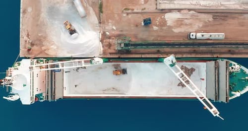 Vista aérea. El barco llegó al puerto. Descarga de un buque de carga mediante una excavadora dentro del
barco