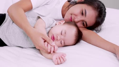 Loving Mother and Child Sleeping on Bed