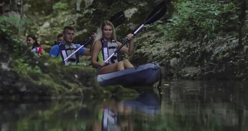 Group Kayaking Down Tropical River in Summer
