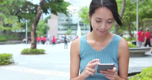 Young Woman use of mobile phone in the park