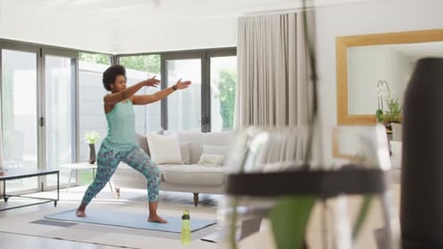 Happy african american wearing sportswear, exercising, using laptop