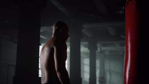 Boxer Standing in Sport Club with Punch Bag