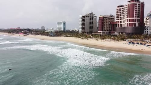 Beautiful Waves in the Sea Impressive White Sand Beach and Buildings Aerial View on a Serene Summer