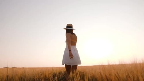 Happy Free Young Woman Dancing and Spinning Around in Slow Motion Across Field Touching Ears of