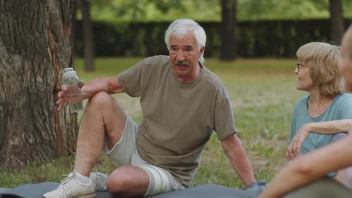 Senior Man and Woman Chatting after Outdoor Workout in Park