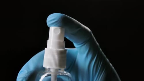 Gloved Hand Sanitizing With a Clear Spray Bottle