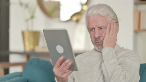 Senior Man Using Tablet at Home is Stressed