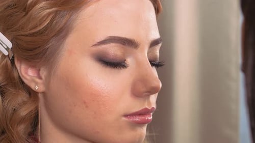 Aplicando maquillaje. Dando los ojos de la expresión de la joven. Extensiones de pestañas en el ojo.