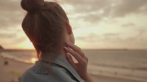 Young Woman Admiring the Sunset By the Sea