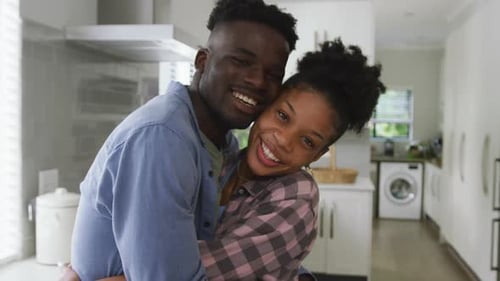 Smiling Couple Embracing in Bright Kitchen