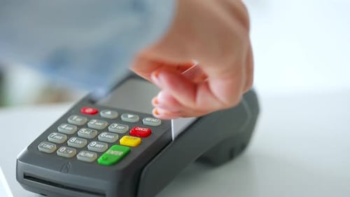 Hand Swiping Credit Card Through Payment Terminal