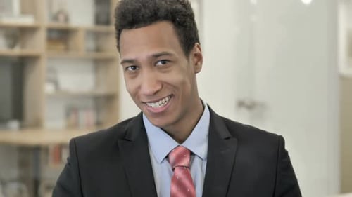 Young Man Smiling and Gesturing Call Me