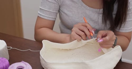 Woman Crocheting Yarn Craft at Table Indoors