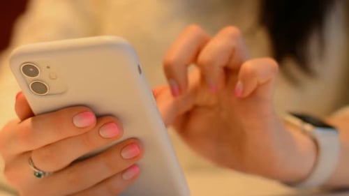 Woman Uses Smartphone in a Close Up Shot