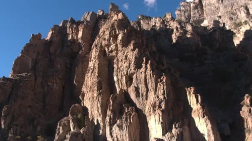 Aerial shot of mountainside cliff formations up a canyon
