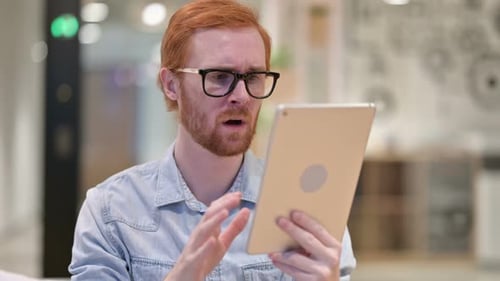 Man with Red Hair Using Tablet in Office