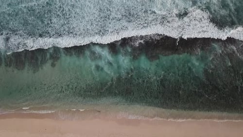 Aerial Top View of Ocean Waves Break on a Beach