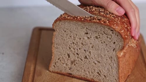 Loaf of Bread Sliced on Wooden Cutting Board