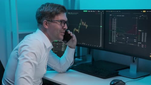 Home trader with phone and trading charts on stock market on computer screen at home