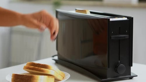 Woman Loads Bread Slices into Black Toaster