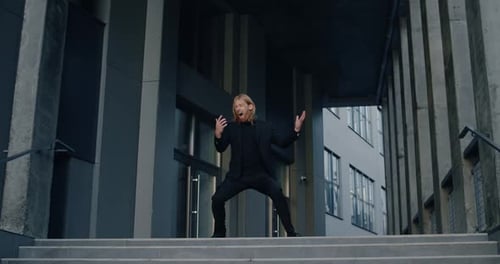 Geschäftsmann machte einen aufgeregten Gesichtsausdruck und fing an zu tanzen und zu lächeln. Erfolgreich gutaussehend