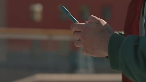 Close Up of Man Texting on Mobile While Walking