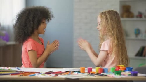Girls Playing Clapping Game Together at Table