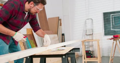 Man Working on Wood in Workshop