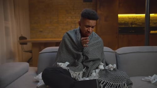 Young Adult Suffering from a Cold Uses Tissues