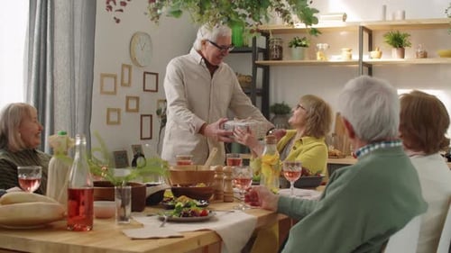 Senior Friends Celebrating Birthday with Gifts and Hugs