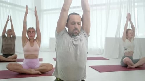 Adults Practicing Yoga Poses in Bright Studio