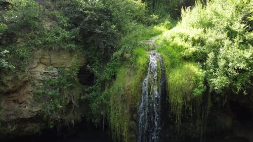 Luftaufnahme eines schönen Wasserfalls mit blauem See im Wald.