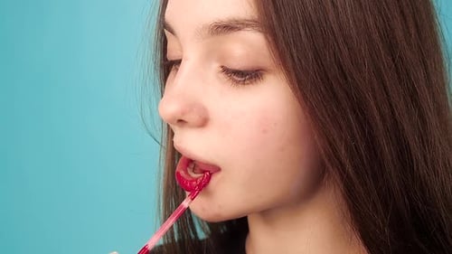 Young Adult Applying Red Lip Gloss, Beauty Shot