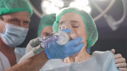 Des médecins réactifs Aide la patiente à se calmer, elle s'est réveillée pendant l'anesthésie.