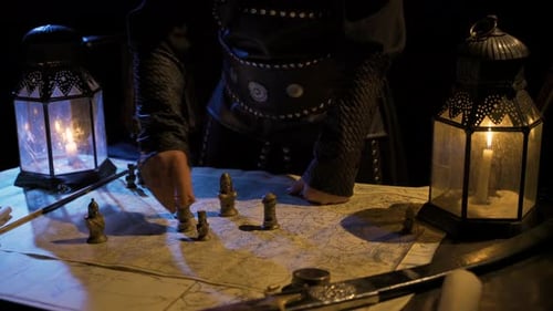 Strategist Moves Chess Pieces on War Map by Candlelight
