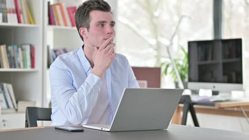 Young Adult Typing on Laptop at Desk