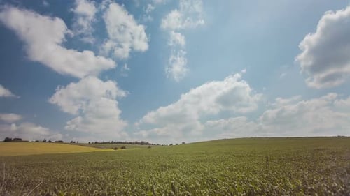 Time Lapse of clouds over green rural landscape with trees and green hills