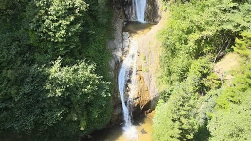 Picturesque Waterfall Cascading Down Cliffside, Lush Greenery