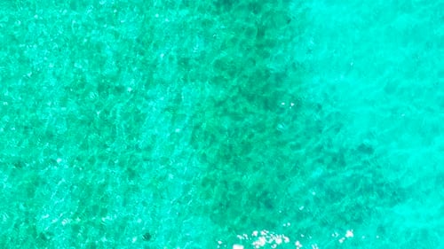 Meeresoberfläche in einer türkisfarbenen Lagune, Ansicht von oben. Transparentes türkises Meerwasser, natürlicher Hintergrund