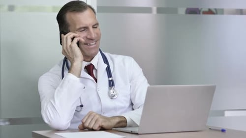 Adult Doctor Talking on Phone in Office